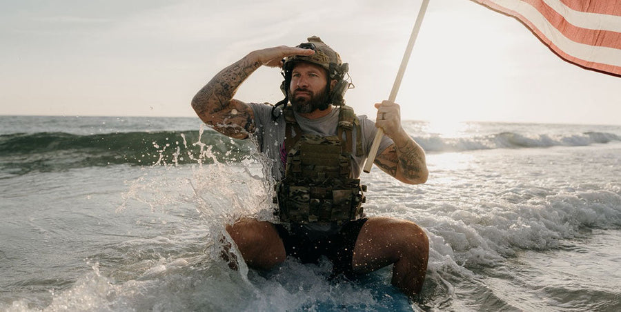 Man on surf board holding American Flag