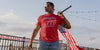 man in grunt style t-shirt holding american flag