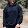 Person wearing a navy hoodie with red graphics outdoors