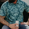 Person wearing a teal floral patterned shirt holding a can.
