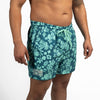 Teal swim shorts with a pattern on a white background