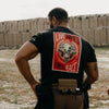 Person wearing a black t-shirt with a graphic design on the back, standing in an outdoor setting.
