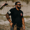 Man in tactical gear with a gun and tactical shirt outdoors