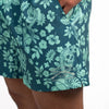 Teal swim shorts with skull and floral pattern on a white background