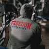 Person wearing a gray hoodie with 'Freedom University' printed on the back in a gym setting.