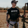 Man wearing a black t-shirt with 'SIZE MATTERS' text, holding a rifle in an outdoor setting.