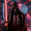 Person in a dark hooded cloak holding a red lightsaber with a humorous 'About to Start Some Sith' t-shirt.