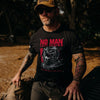 Man wearing a black t-shirt with 'No Man Left Behind' graphic design outdoors.