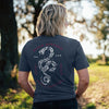 Person wearing a dark blue t-shirt with a snake design and text outdoors.