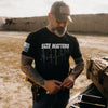 Man wearing a black t-shirt with 'SIZE MATTERS' text and tattoos, standing outdoors.