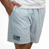 Light blue shorts with an American flag patch worn by a person on a white background