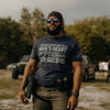 Man wearing a tactical outfit with a shirt and sunglasses, standing outdoors.