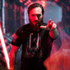 Person wearing a black t-shirt with a graphic design, holding a red lightsaber in a dramatic pose.