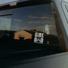 Sticker on a car window with 'Girl Dad' text and reflection of a building.
