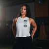 Woman wearing a white tank top with logos in a gym setting