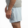 Light blue shorts with a brand logo worn by a person on a white background