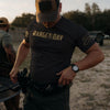 Man wearing a 'RANGE DAY' t-shirt outdoors with another person in the background.