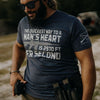 Man wearing a t-shirt with a graphic and text, holding a gun, outdoors.
