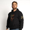 Man wearing a black hoodie with a graphic design on a white background
