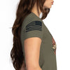 Person wearing an olive green t-shirt with a flag design on a white background