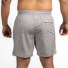 Gray shorts with a subtle pattern worn by a person on a white background