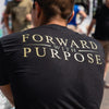 Person wearing a black t-shirt with 'Forward with Purpose' text on the back.