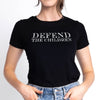Person wearing a black t-shirt with 'DEFEND THE CHILDREN' text on a plain background