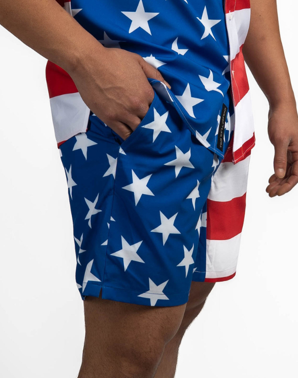 Person wearing shorts with a star pattern on a plain background
