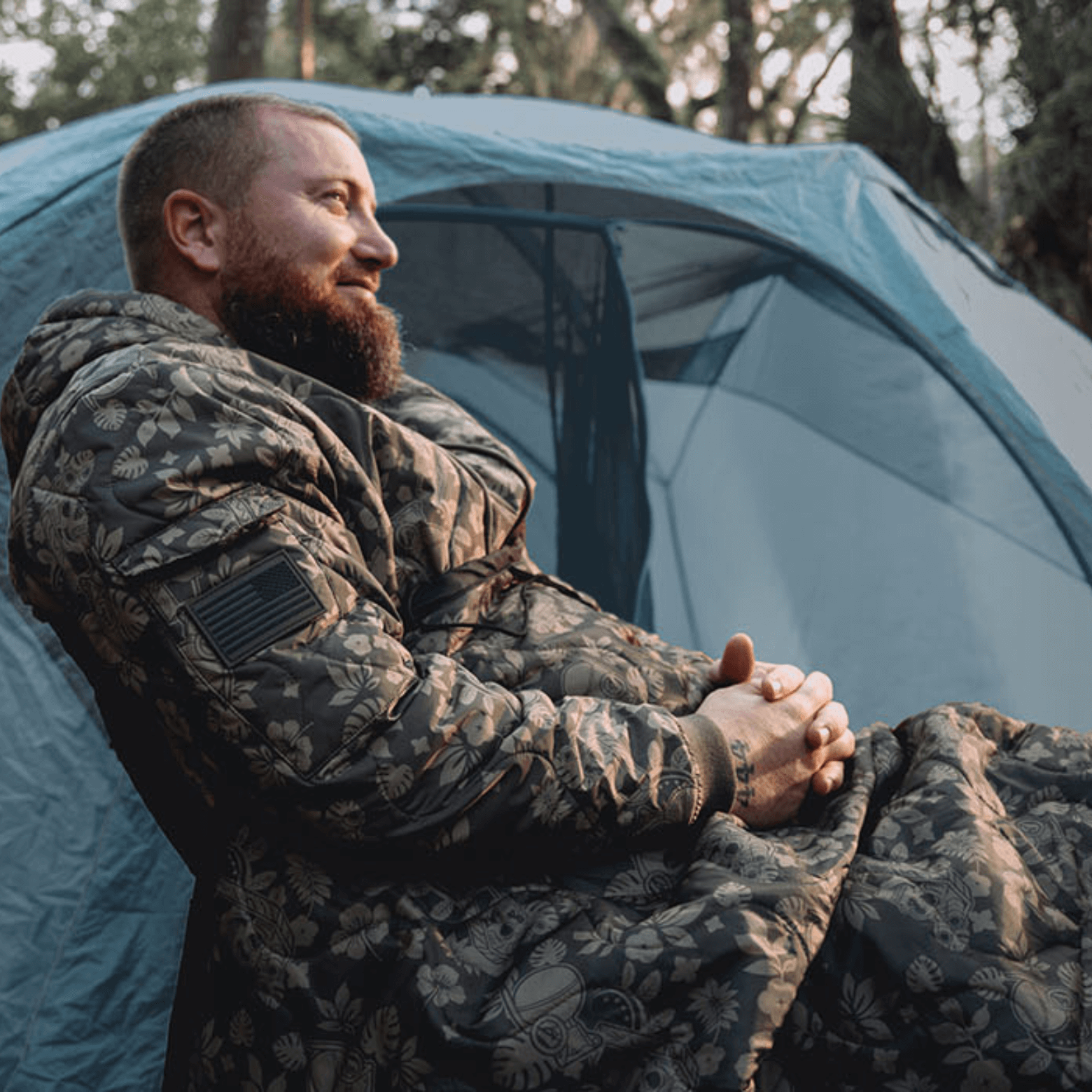 tent camping while wearing a Woobie Hoodie in frog skin forest pattern