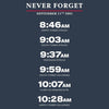 A dark slate blue graphic with white text reading 'NEVER FORGET' and 'SEPTEMBER 11TH 2001,' followed by chronological event times and locations: North Tower struck at 8:46 AM, South Tower struck at 9:03 AM, Pentagon struck at 9:37 AM, South Tower collapses at 9:59 AM, Flight 93 crashes in PA at 10:07 AM, and North Tower collapses at 10:28 AM.