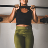 Woman doing a pullup while wearing the military green women's fitness leggings by Grunt Style